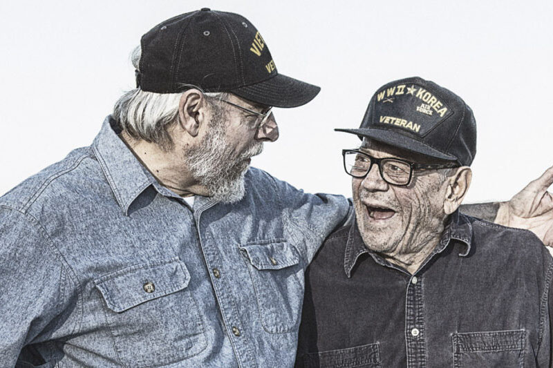 World war II Veterans are sharing a hug.