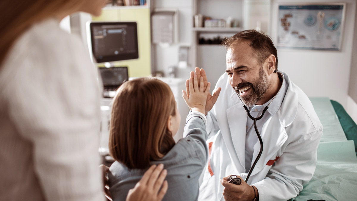 A child giving a high-five to a doctor.