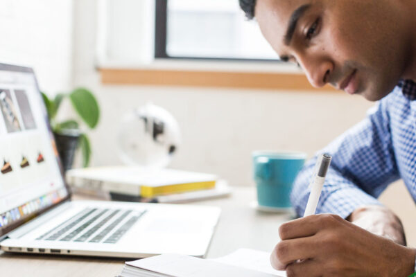 Summer Analyst taking notes during Lean Six Sigma Yellow Belt training.